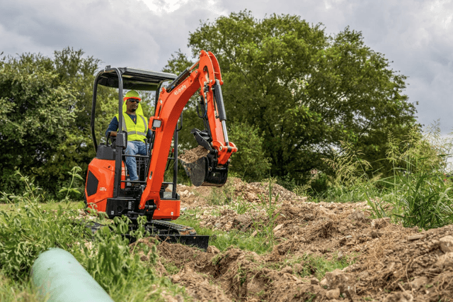 Man operating compact excavator