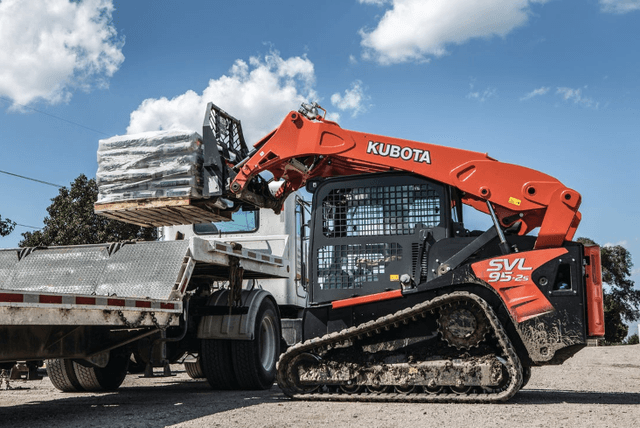 Track Loader loading a pallet onto the back of truck