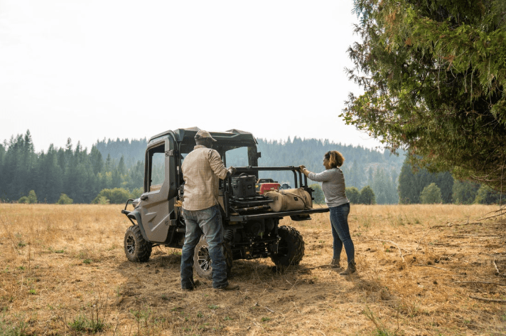 A couple unloading the cargo bed of RTV