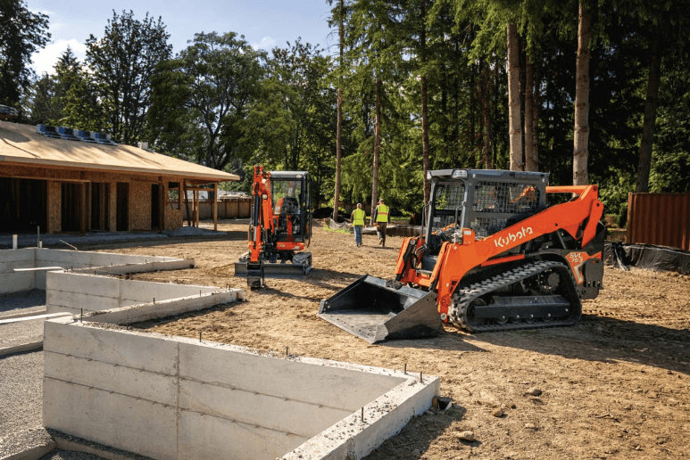 Track loader and excavator on a job site