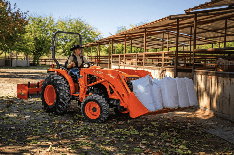 Tractor loading heavy material to a stable