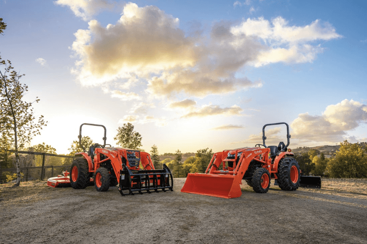 Two tractors pictured in front of a beautiful sunset